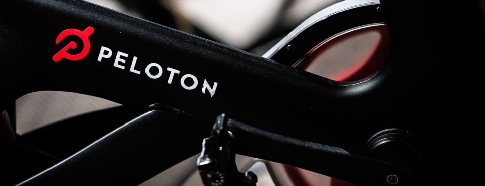 The Peloton Interactive Inc. logo is displayed on a stationary bicycle